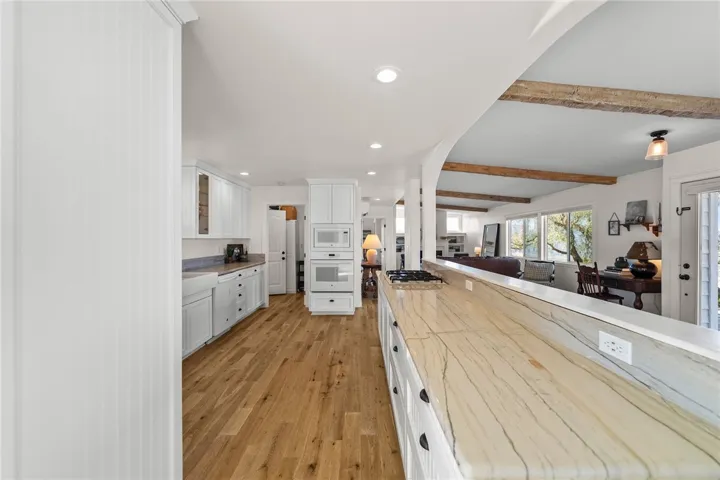 Both Kitchens Showcase Custom-Built Cabinetry, Quartz Countertops, Farmhouse Sinks, And High-End Finishes
