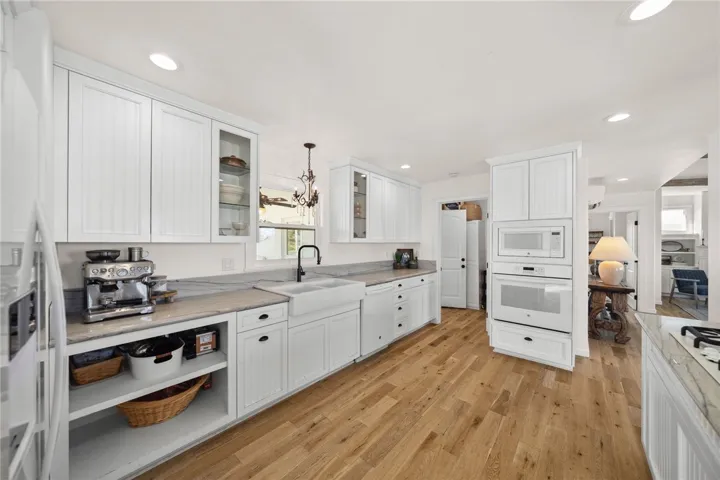 Both Kitchens Showcase Custom-Built Cabinetry, Quartz Countertops, Farmhouse Sinks, And High-End Finishes