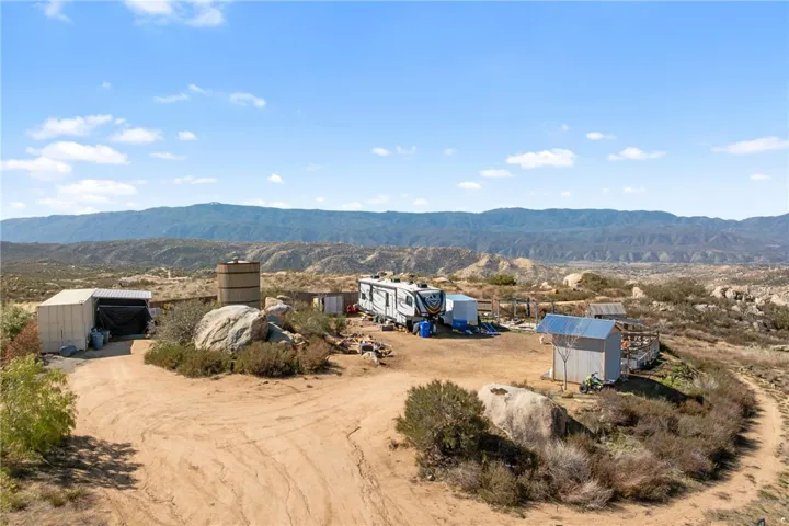 A 50' Cargo Container With An Attached Shed Cover, RV Hookups, And Perimeter Cattle Fencing