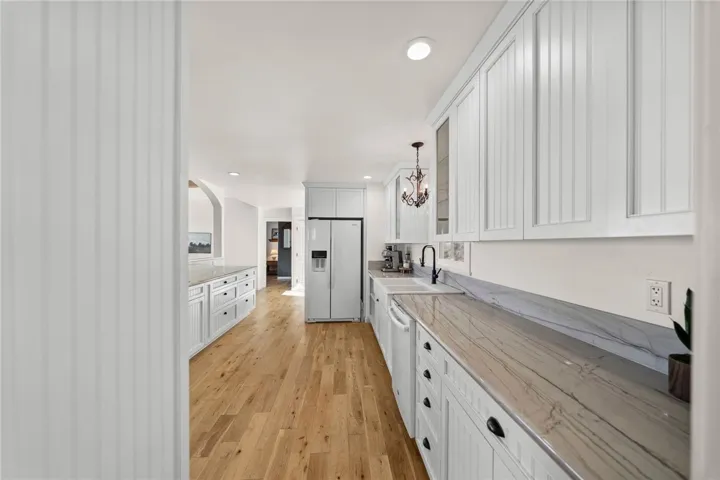 Both Kitchens Showcase Custom-Built Cabinetry, Quartz Countertops, Farmhouse Sinks, And High-End Finishes
