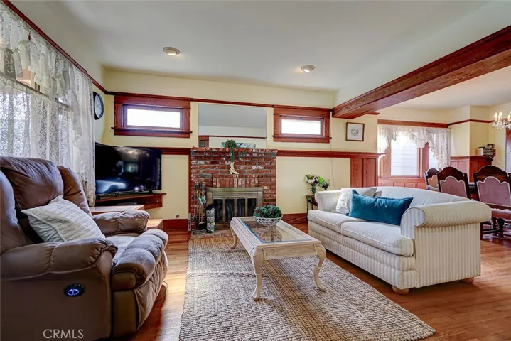 Great room has original oak hardwood floors, original ceiling beam, wood paneling and picture shelf!

