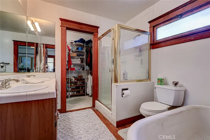 spacious bathroom with double sinks, shower, tub, walk in closet