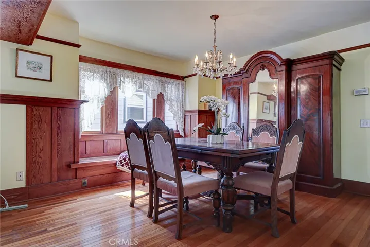 Spacious dining area features a large bay window, window seat, and original large paned windows with leaded glass detail at the top.  Notice the original hardwood floors!
