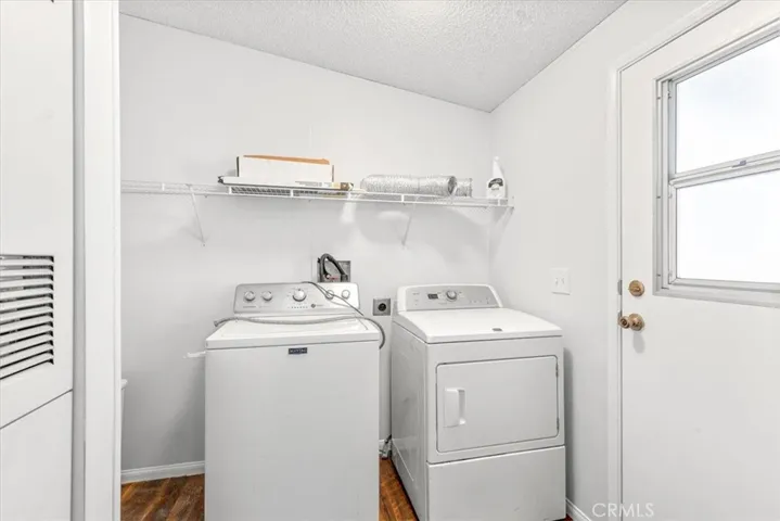 laundry area with shelves and door to cars