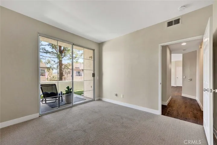 Spacious primary bedroom with sliding door access to private patio
