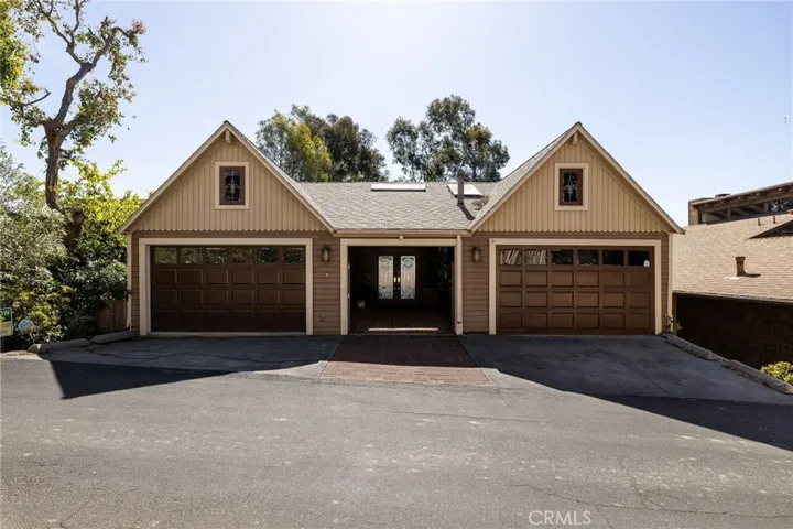 Nestled on a private road with an inviting curb appeal, the property features a double-door courtyard entry and 2 parking pads in the front of the garage doors.