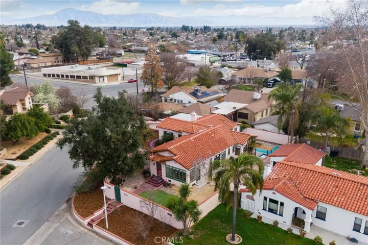 Aerial View: from north side, side yard entry gate, huge live oak tree shading the used red brick side yard patio, red door is backdoor to kitchen, large row of windows is in the Sun Room, side yard entry gate facilitates possible ADU or AirBNB uses.

