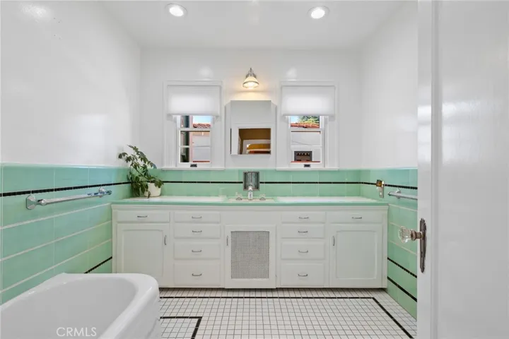 Hall Bathroom: beautiful original period 3-toned tile walls, countertops and flooring, original cabinetry, full-sized bathtub, vintage hardware, ceiling dimmable can lights.

