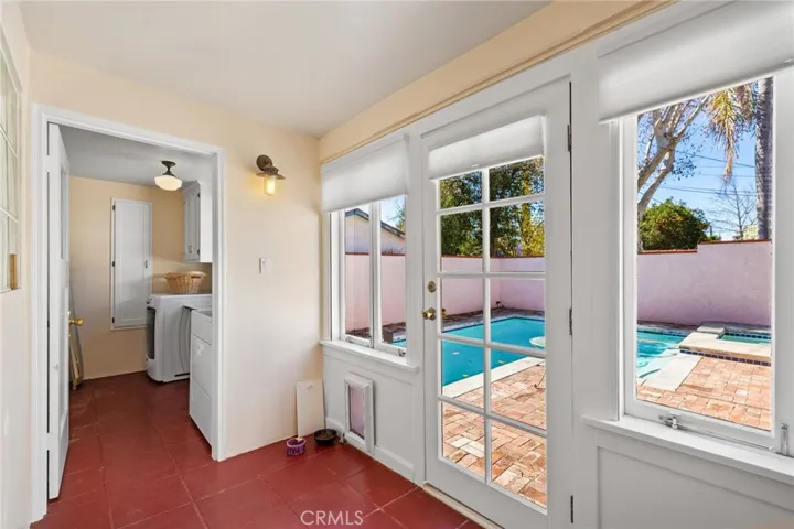 Breezeway Room: cement flooring, big windows, pet access door, door to pool yard, glass block insert in wall at left, laundry room at rear, South (3rd) Bedroom out of site at left. Clothes washer and clothes dryer are included!