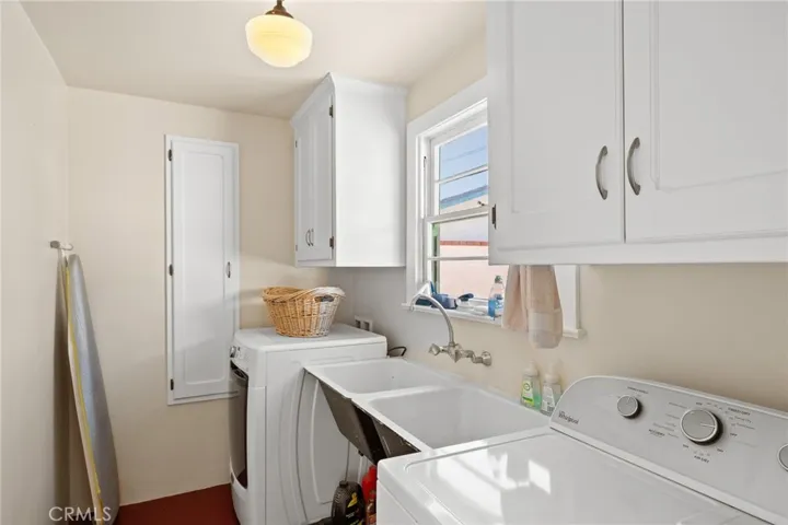 Laundry Room: The clothes washer and clothes dryer are included! Original built-in ironing board, cabinets, double deep service sinks, period ceiling light fixture, gas hook-ups, cement flooring.