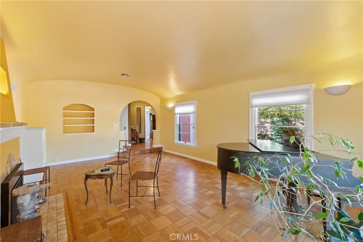 Formal Living Room: opposite view, recessed built-in bookshelves, original built-in cabinets, custom dimmable wall sconces, archway to entry foyer.

