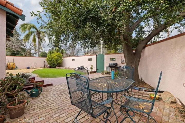 North Side Yard: used red brick patio, large live oak tree, gate to side street, astroturf lawn, solid high walls for privacy and security.

