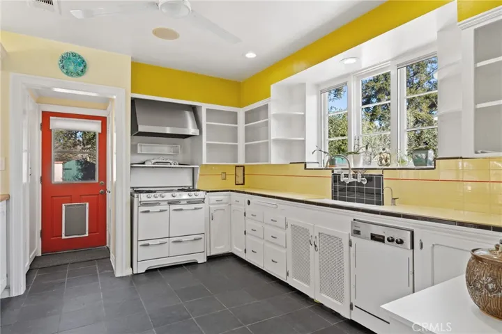 Kitchen: valuable vintage period O'Keefe & Merritt 4-burner+griddle gas range is included-highly sought after by serious cooks for superior cooking qualities, original 4-color tlle countertops and full backsplash, New dishwasher, disposal, stainless steel real vent hood, original cabinets, through-the-wall milkdrop, match holder, garbage chute, slate tile flooring, new ceiling fan, newer recessed dimmable ceiling can lights, ceiling speaker for sound system, pantry closets with vintage swing-out shelving...