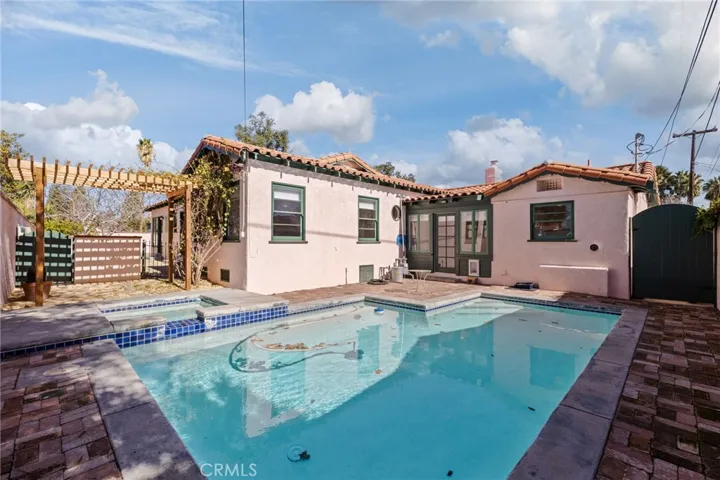 Pool & Spa: opposite view towards breezeway room, custom gate to side yard and carport at right, new wood pergola at left, all new pool filtering & heating system behind green gate at left, gate to backyard next to house.

