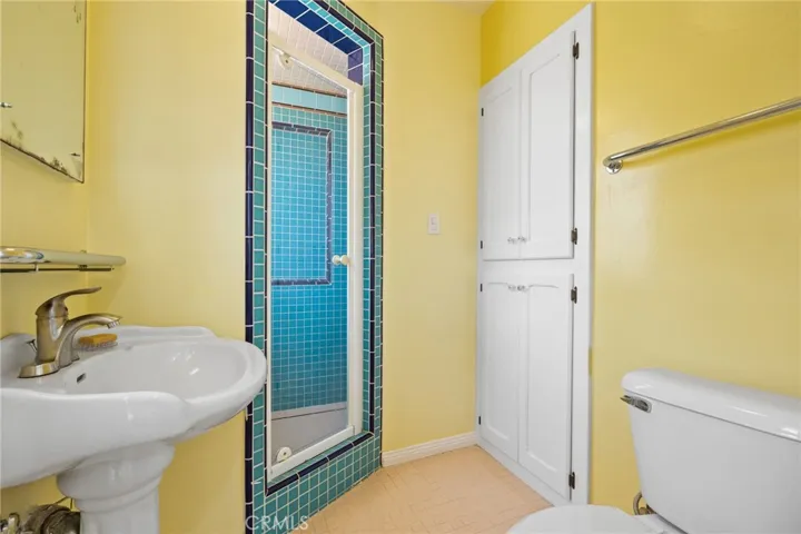 Attached Bathroom: tile flooring, full-tile shower, large linen storage cabinet, vintage medicine cabinet & mirror, newer toilet.

