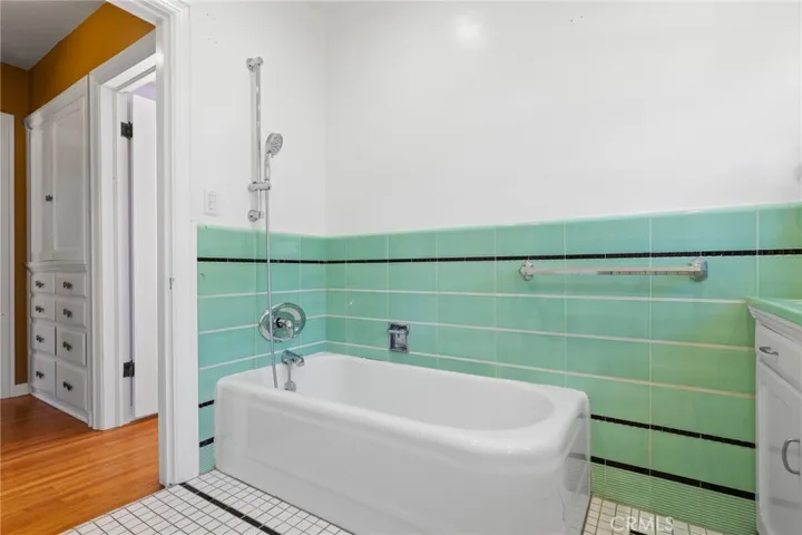 Hall Bathroom: bathtub & Euro-style shower details, all new fixtures, entire house has all new ptex plumbing and all new drain lines too, view to hallway to entry foyer with large linen storage cabinets, whole-house sound system equipment in the cabinet in included!

