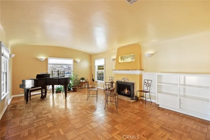 Formal Living Room: classic full-sized room, original parquet wood flooring, dramatic barrel-vaulted ceiling, full-sized tiled fireplace with gas insert & fresco of the Santa Barbara Mission, custom dimmable wall sconces, built-in cabinets and shelves, new insulated shades on all windows throughout the house, floor mouldings.

