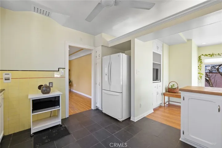 Kitchen: white refrigerator/freezer with ice maker is included! View to Sun Room, breakfast bar at right.