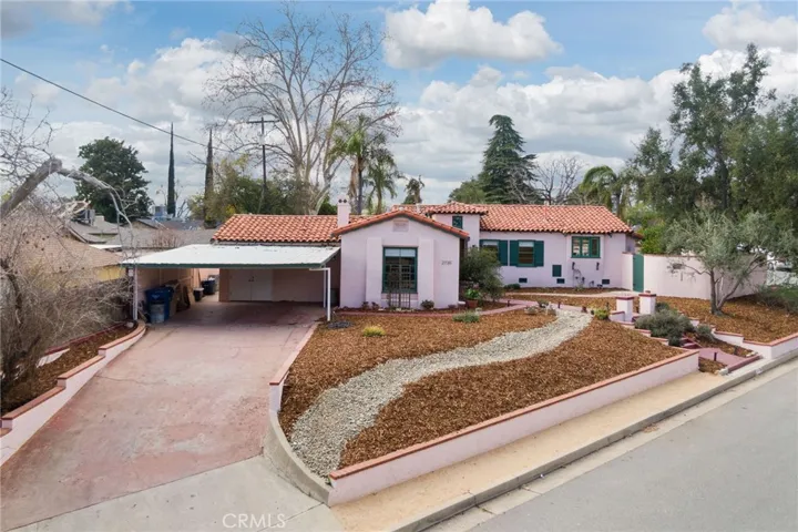 East facing Front Elevation: new xeriscape front yard landscaping, long & double-wide driveway, 2+car covered carport, could easily be converted to a fully enclosed garage, double doors at rear of carport to 5'x10'shop/storage closet.

