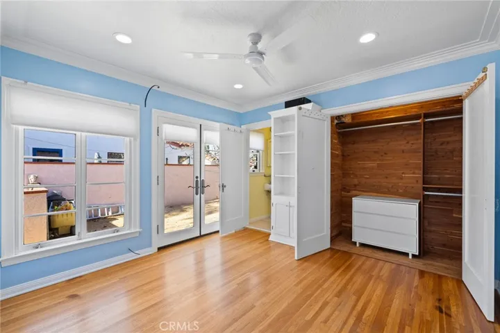 North Bedroom: large-sized, attached 3/4 bathroom, Original hardwood flooring, large cedar-lined closet, built-in cabinet unit, wide sculpted mouldings, french doors to backyard, big windows, new insulated shades, new ceiling fan, recessed dimmable ceiling can lights.

