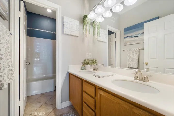 Upstairs secondary bath with dual vanities, tub and shower.