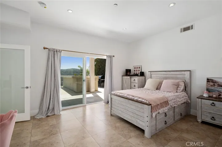 Downstairs bedroom with ensuite bathroom, walk-in closet and glass sliders with direct patio access