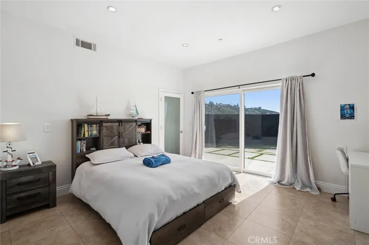Downstairs bedroom with ensuite bathroom, walk-in closet and glass sliders with direct patio access