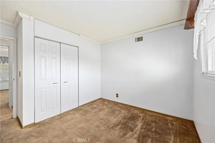Bedroom 1 down hallway with window to backyard, closet