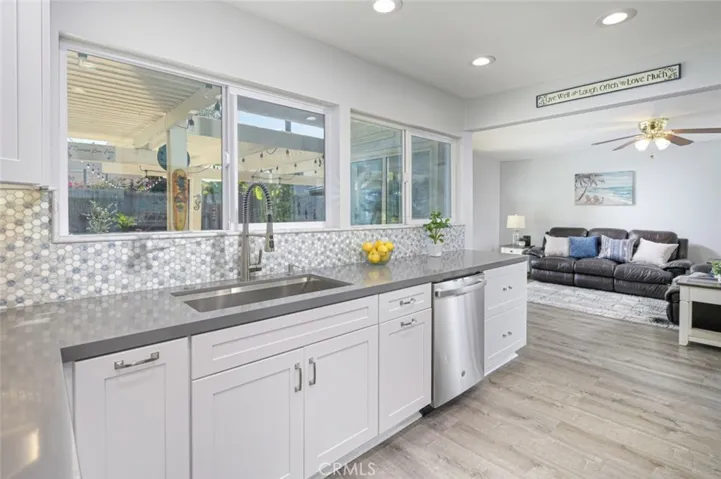 View of the kitchen looking into the family room.   Windows flank the walls in this room so there is a ton of light!