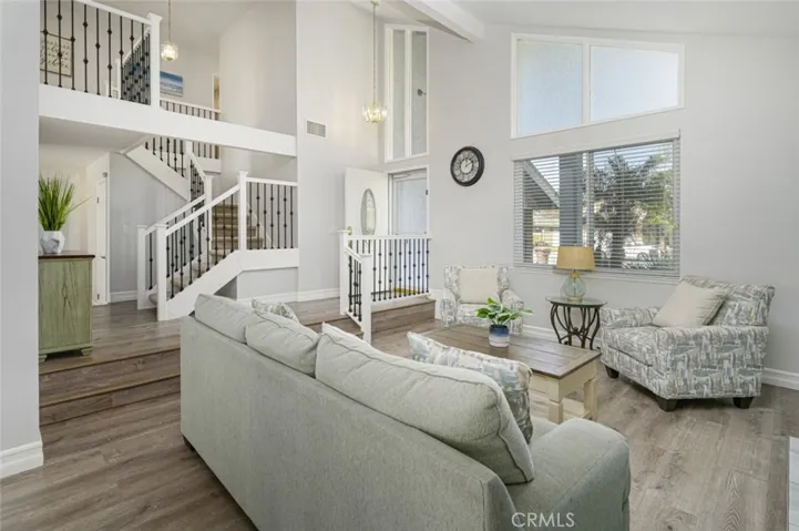 Living Room has LVP flooring with weatherproof cushion.   Stairway was remodeled with wrought iron decals and wooden railings.