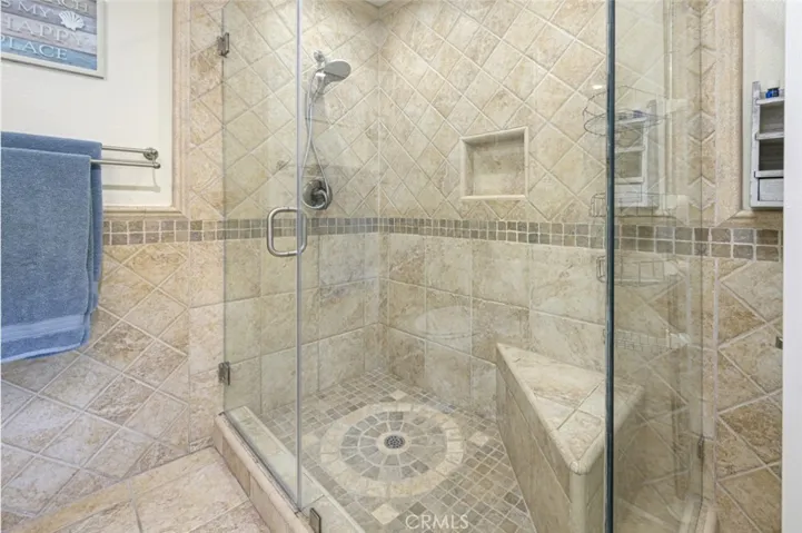 Primary Bathroom tiled walk in shower with glass enclosure.
