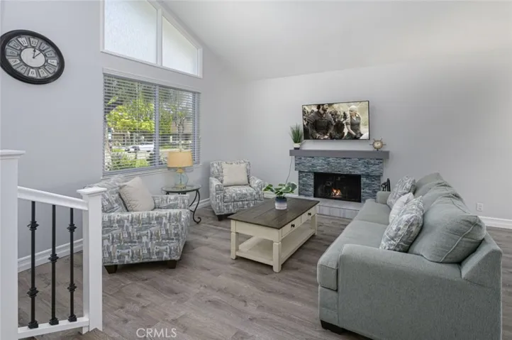Living Room has LVP flooring with weatherproof cushion.  The fireplace has been upgraded with custom tiles & has a wood mantle.