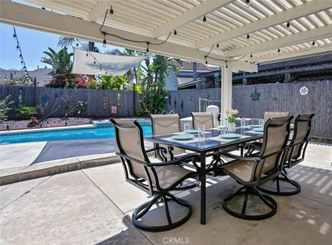 Backyard under the patio cover with view of the pool & spa.
