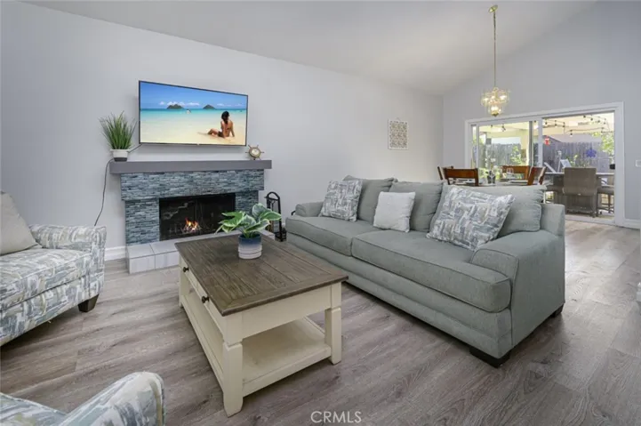 Living Room has LVP flooring with weatherproof cushion.  The fireplace has been upgraded with custom tiles & has a wooden mantle.  The dining room has a sliding door that leads to the backyard.