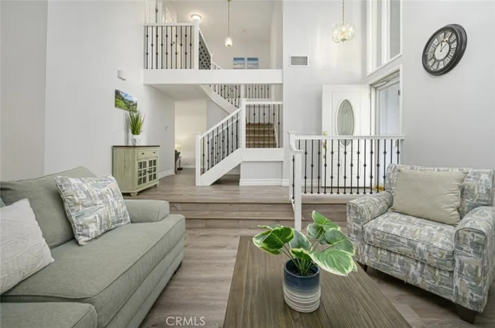 View of the newly renovated staircase from the living room.   The front door has a retractable screen door.