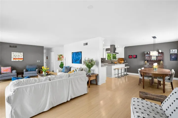Approximately 1,559 square feet, the three-bedroom, two-bath residence features a spacious living room anchored by an elegant fireplace and two sets of French doors that open to the deck.