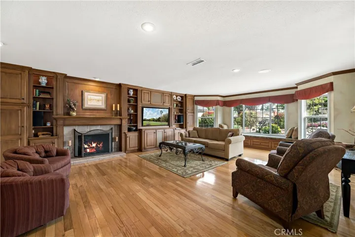 HUGE great room for entertaining w hardwood floors, built in cabinet, fireplace and entertainment center