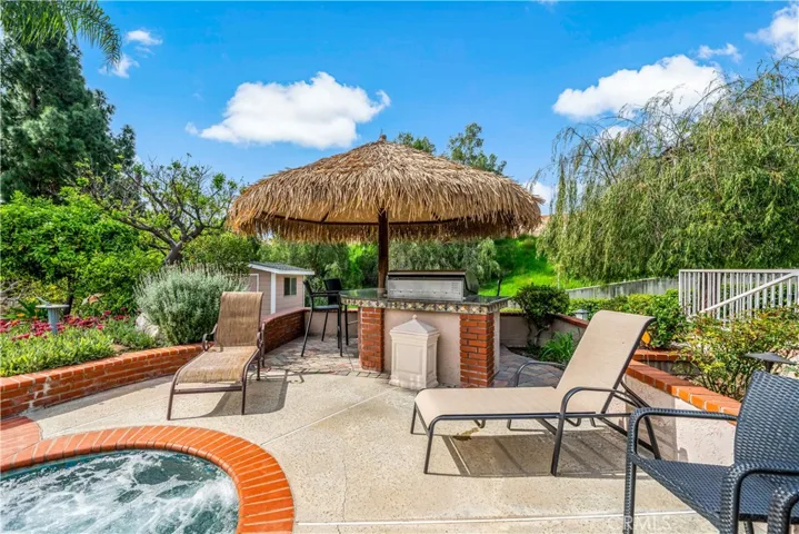 Outdoor barbeque/bar area under palapa w built in fridge.