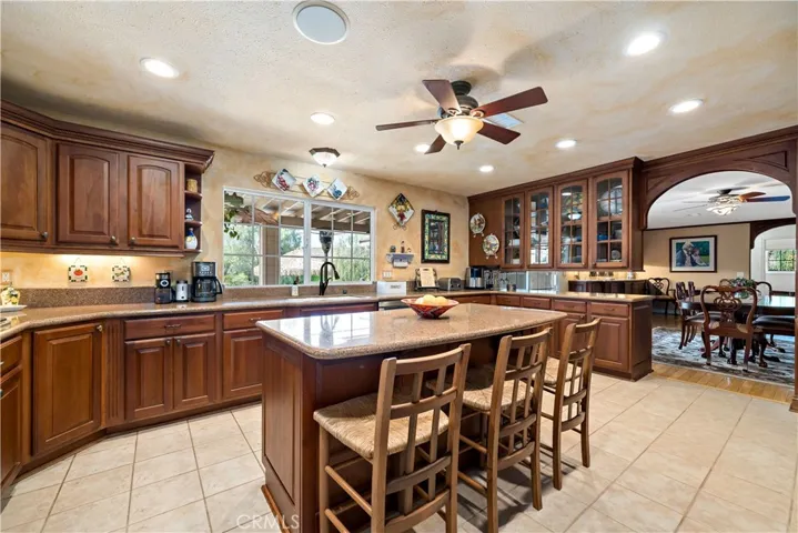 Custom kitchen w recessed lighting, ceiling fan/light fixture and center island w breakfast bar