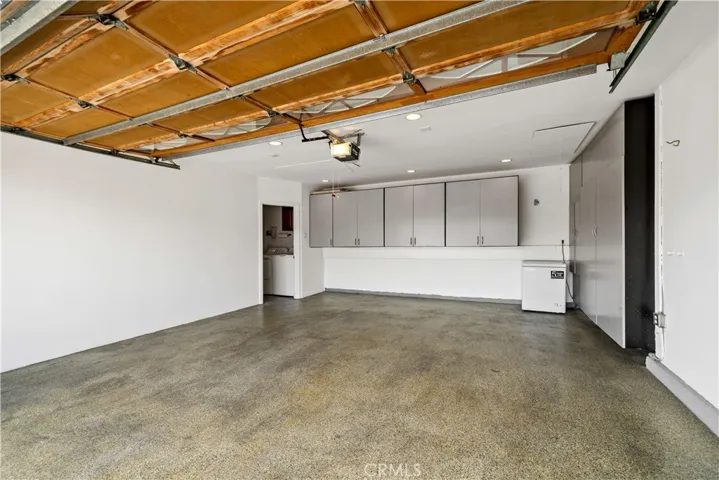 Epoxy finished flooring and built in cabinetry space in 2 car space w 220V outlet in cabinet on right to accommodate an EV charging station