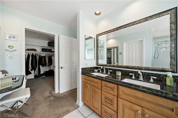 Primary bathroom w doorway to walk-in closet