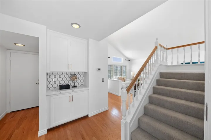 Base of the stairs with  door on the left to access the 3 car garage.