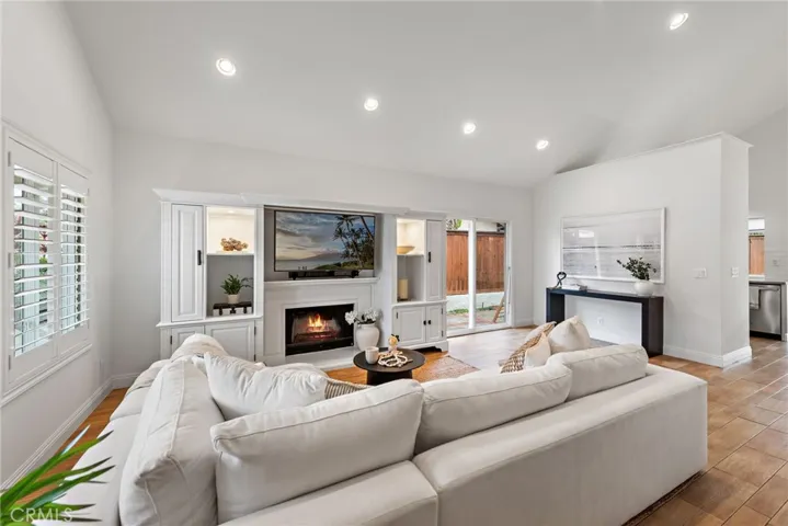 Open floor plan with wood tile flooring, vaulted ceilings and fireplace to enjoy.
