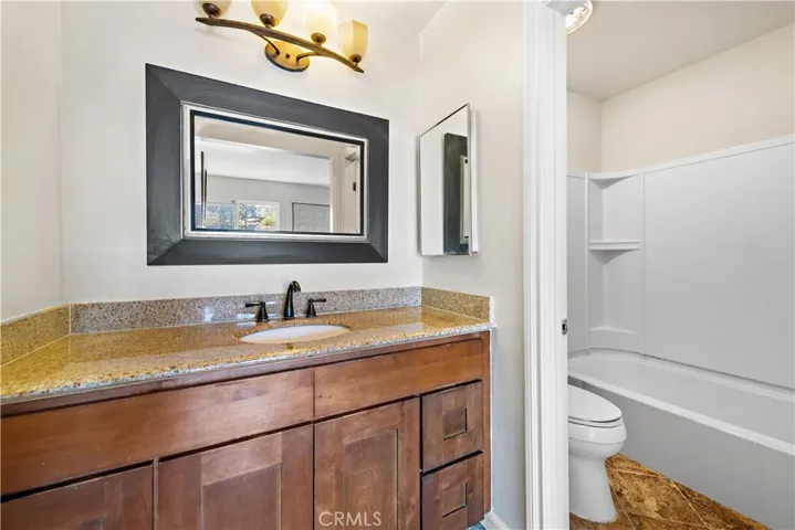 Remodeled bathroom in the second primary bedroom.  Complete with newer fixtures, granite counters and newer cabinets.