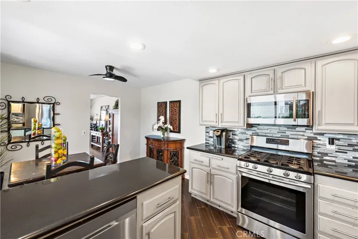 Notice how the backsplash compliments and brings together the other beautiful touches. The nook is a welcome addition for additional seating.  The area could also be used as a small office.