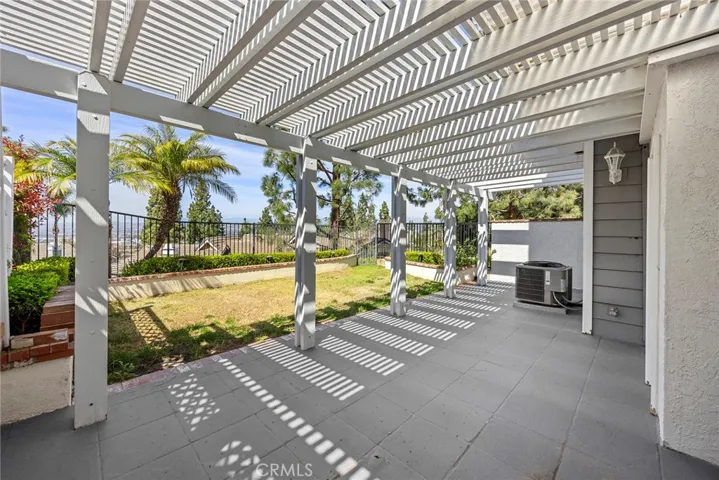 BACKYARD WITH COVERED PATIO AND CITY LIGHTS VIEW.