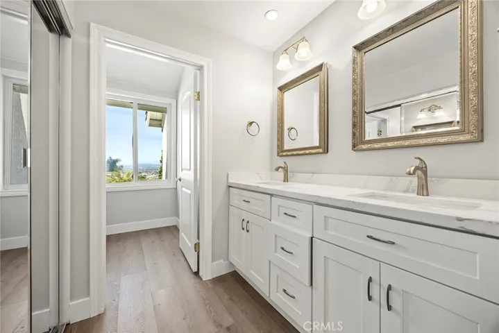 MASTER BEDROOM DRESSING AREA WITH REMODELED BATH AND MIRRORED CLOSET DOORS.
