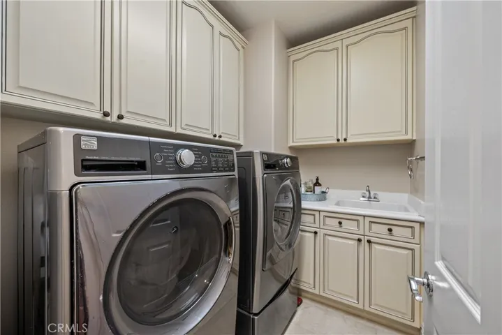 Thoughtfully Located Upstairs with Sink and Ample Storage the Front Load Washer/Dryer are Complete with Storage Risers