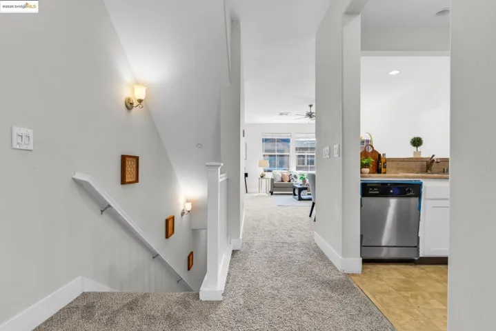 Stairs featuring carpet, tile patterned floors, and a ceiling fan