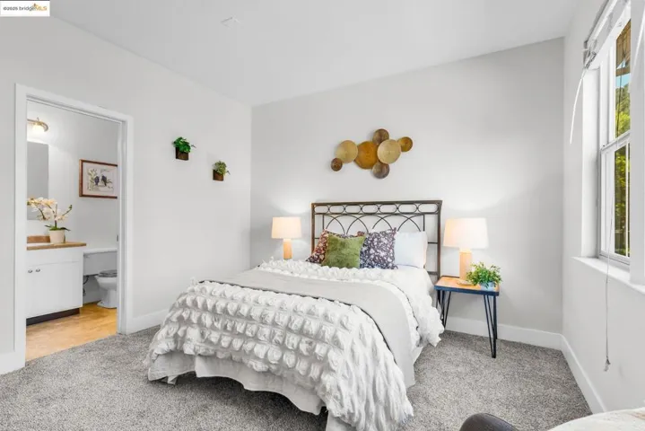 Bedroom featuring light colored carpet and ensuite bath